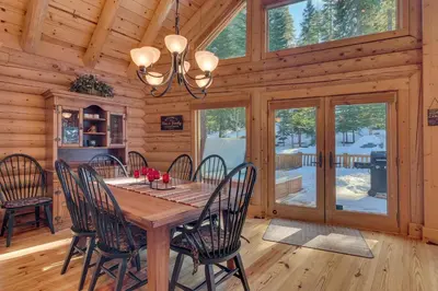 a dining room with a wooden table and chairs at Lodgepole Retreat - A Gorgeous Classic 3BR Log Cabin with Private Hot Tub in Truckee