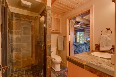 a bathroom with a shower and a toilet and a sink at Lodgepole Retreat - A Gorgeous Classic 3BR Log Cabin with Private Hot Tub in Truckee