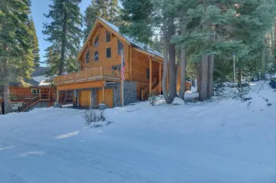 a log cabin in the woods in the snow at Lodgepole Retreat - A Gorgeous Classic 3BR Log Cabin with Private Hot Tub in Truckee