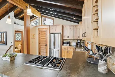 a kitchen with a stainless steel refrigerator and a stove at Mariposa Heights at Alpine - Ski Shuttle to Slopes- Fireplace- Forest Views in Alpine Meadows