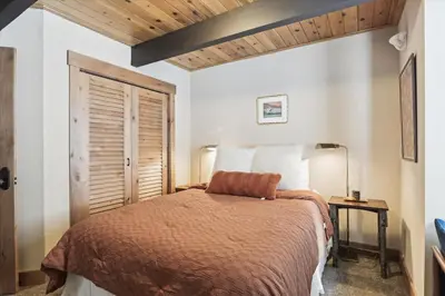 a bedroom with a bed and a wooden ceiling at Mariposa Heights at Alpine - Ski Shuttle to Slopes- Fireplace- Forest Views in Alpine Meadows