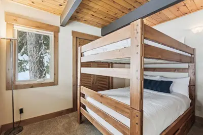 a bedroom with a bunk bed and a window at Mariposa Heights at Alpine - Ski Shuttle to Slopes- Fireplace- Forest Views in Alpine Meadows