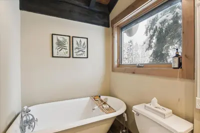 a bathroom with a tub and a toilet and a window at Mariposa Heights at Alpine - Ski Shuttle to Slopes- Fireplace- Forest Views in Alpine Meadows
