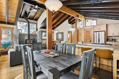 a kitchen and dining room with a wooden table and chairs at Mariposa Heights at Alpine - Ski Shuttle to Slopes- Fireplace- Forest Views in Alpine Meadows