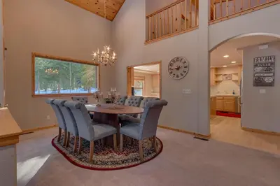 a dining room with a table and chairs and a clock at Matterhorn at Tahoe Donner 3000 Sqft 4 BR with Private Hot Tub and HOA Pool, Gym and Beach Access in Truckee