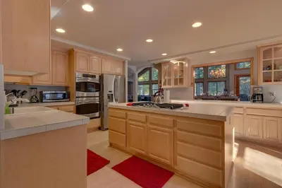 a large kitchen with wooden cabinets and a red rug at Matterhorn at Tahoe Donner 3000 Sqft 4 BR with Private Hot Tub and HOA Pool, Gym and Beach Access in Truckee