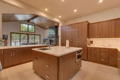 a large kitchen with wooden cabinets and a sink at Meek Court at Grays Crossing - Modern Luxury with Private Hot Tub in Truckee