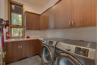 a washing machine in a kitchen with wooden cabinets at Meek Court at Grays Crossing - Modern Luxury with Private Hot Tub in Truckee