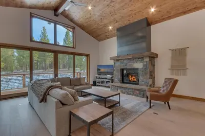 a living room with a couch and a fireplace at Meek Court at Grays Crossing - Modern Luxury with Private Hot Tub in Truckee