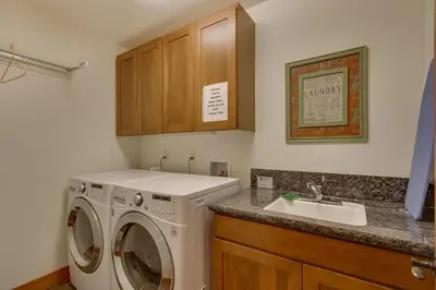 a laundry room with a washing machine and a sink at Mountain Escape at North Shore - Upscale 4BR Easy Walk to Lake & Private Hot Tub! in Carnelian Bay