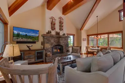 a living room with a couch and a fireplace at Mountain Escape at North Shore - Upscale 4BR Easy Walk to Lake & Private Hot Tub! in Carnelian Bay