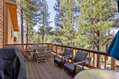 a deck with a table and chairs and trees at Mosaic Magic at Northstar - Luxury 4BR with Private Hot Tub and Free Ski Shuttle in Truckee