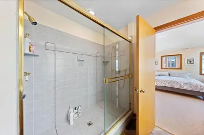 a bathroom with a glass shower with a bed at Mosaic Magic at Northstar - Luxury 4BR with Private Hot Tub and Free Ski Shuttle in Truckee