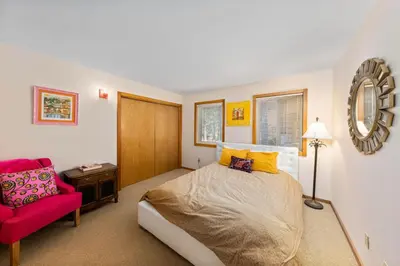 a bedroom with a bed and a red chair at Mosaic Magic at Northstar - Luxury 4BR with Private Hot Tub and Free Ski Shuttle in Truckee