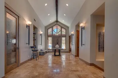 a hallway with a large window and a table in it at Mountain Majesty at Grays Crossing - Luxury 4BR 4BA w Private Hot Tub in Truckee