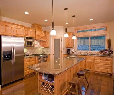 a kitchen with wooden cabinets and a stainless steel refrigerator at Olive Branch - Private Hot Tub, Media Room, Pet-Friendly, Near Northstar! in Carnelian Bay