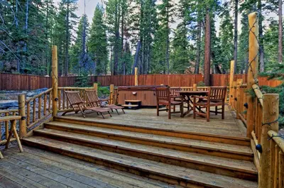 a wooden deck with a table and chairs on it at Olive Branch - Private Hot Tub, Media Room, Pet-Friendly, Near Northstar! in Carnelian Bay