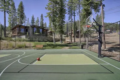 a basketball court with a house in the background at Mountainside by Tahoe Getaways - Luxury Pet-Friendly Northstar Ski-in Ski-Out - Swimming Pool and Gym! in Truckee