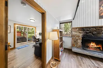 a living room with a fireplace and a chair at Ellis Peak Retreat - Hot Tub, Wood Fireplace, Close to Tahoe City & Dining in Tahoe City
