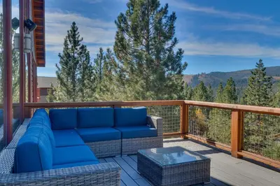 a blue couch sitting on a deck with a view at Pinnacle Views at Tahoe Donner - 4BR, Hot Tub in Truckee