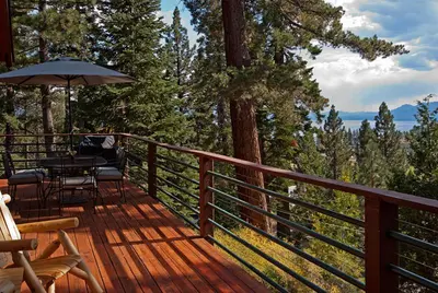 a wooden deck with a table and an umbrella at Pioneer Lake View- 4BR Easy Walk to Town Private Hot Tub - Sleeps 11 in Tahoe City