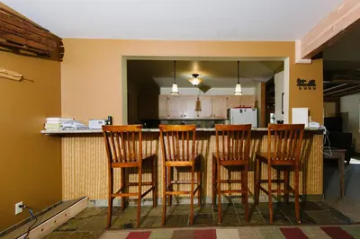 a kitchen with a bar with four wooden chairs at Pioneer Lake View- 4BR Easy Walk to Town Private Hot Tub - Sleeps 11 in Tahoe City