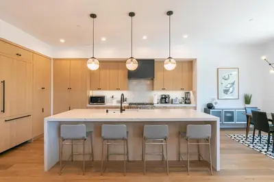 a kitchen with a large island with bar stools at Powder Run - Newly Built Palisades 3 Bedroom Townhome - Minutes to Village in Olympic Valley