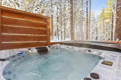 a jacuzzi tub in the snow in a forest at Ponderosa Pines - Custom 3 BR - Pet Friendly Private Hot Tub - Ski Shuttle in Truckee