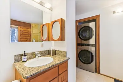 a bathroom with a sink and a washing machine at Ponderosa Pines - Custom 3 BR - Pet Friendly Private Hot Tub - Ski Shuttle in Truckee