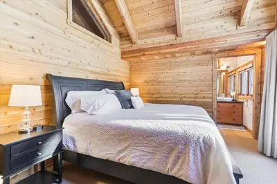 a bedroom with a bed in a wooden cabin at Ponderosa Pines - Custom 3 BR - Pet Friendly Private Hot Tub - Ski Shuttle in Truckee
