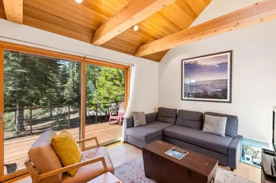 a living room with a couch and a table at Wildwood - Modern 2 BR with Private Hot tub Walk to North Tahoe Regional Park in Tahoe Vista