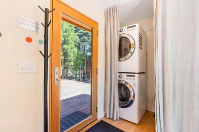 a laundry room with a door and a washer and dryer at Wildwood - Modern 2 BR with Private Hot tub Walk to North Tahoe Regional Park in Tahoe Vista