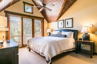 a bedroom with a bed and a ceiling fan at Village Walk - Private Hot Tub, HOA Amenities, Pet Friendly, Walk to Lifts! in Truckee