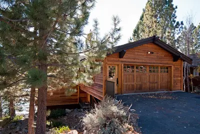 a large wooden cabin with a large garage at Water's Edge Lakefront- Buoy, Private Pier in Tahoe City