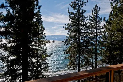 a view of a body of water through some trees at Water's Edge Lakefront- Buoy, Private Pier in Tahoe City