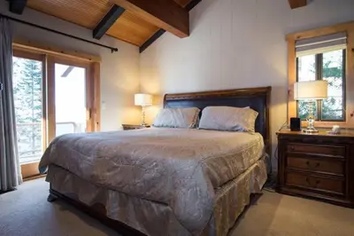 a bedroom with a large bed and two windows at Water's Edge Lakefront- Buoy, Private Pier in Tahoe City
