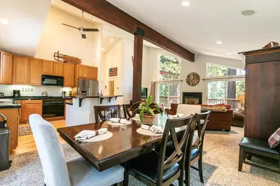 a kitchen and living room with a wooden table and chairs at Wolf Den - Bright Open Concept 3 Bedroom- Hot Tub, Pet-Friendly, Minutes from Skiing! in Tahoma