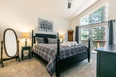a bedroom with a bed and a large window at Wolf Den - Bright Open Concept 3 Bedroom- Hot Tub, Pet-Friendly, Minutes from Skiing! in Tahoma