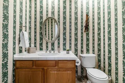 a bathroom with a toilet and a sink and a mirror at Wolf Den - Bright Open Concept 3 Bedroom- Hot Tub, Pet-Friendly, Minutes from Skiing! in Tahoma