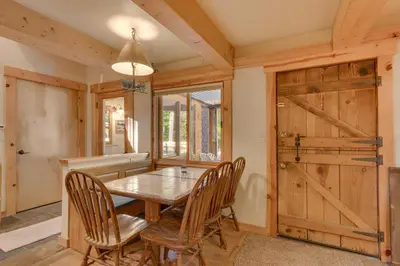 a dining room with a wooden table and chairs at West Pine Cabin on the West Shore by Tahoe Getaways - 2 BR w 2 Bonus Rooms, Hot Tub, Pool Table & Pet Friendly in Tahoe City