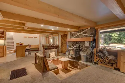 a large living room with a fireplace and a kitchen at West Pine Cabin on the West Shore by Tahoe Getaways - 2 BR w 2 Bonus Rooms, Hot Tub, Pool Table & Pet Friendly in Tahoe City