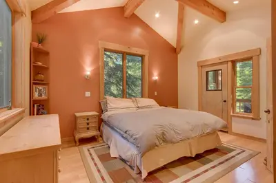a bedroom with a large bed and windows at West Pine Cabin on the West Shore by Tahoe Getaways - 2 BR w 2 Bonus Rooms, Hot Tub, Pool Table & Pet Friendly in Tahoe City