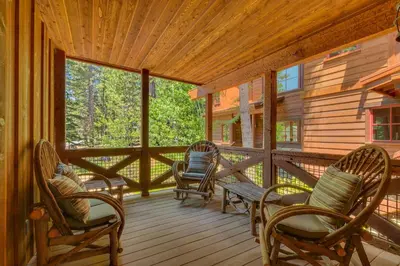 a porch of a cabin with rocking chairs and a bench at New Listing! West Shore Bliss - 4BR, Private Hot Tub in Tahoe City