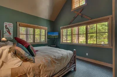 a bedroom with a bed with green walls and windows at New Listing! West Shore Bliss - 4BR, Private Hot Tub in Tahoe City
