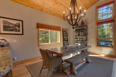 a dining room with a wooden table and a chandelier at Woodcrest at Tahoe Donner 3BR with Pool Table - 3000 sq ft in Truckee