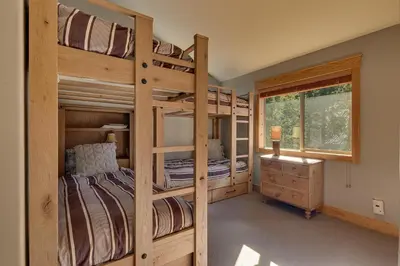 two bunk beds in a room with a window at Woodcrest at Tahoe Donner 3BR with Pool Table - 3000 sq ft in Truckee