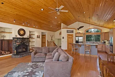 a large living room with a couch and a fireplace at Woodside Lodge on West Shore with Private Hot Tub, Pool Table & Game Room in Tahoma