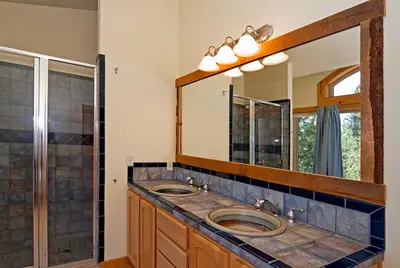 a bathroom with two sinks and a large mirror at Woodside Lodge on West Shore with Private Hot Tub, Pool Table & Game Room in Tahoma