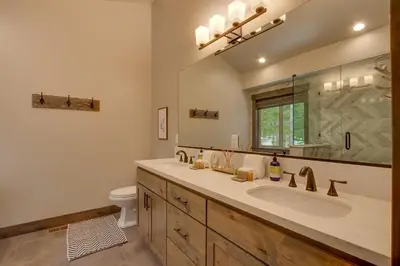 a bathroom with a sink and a mirror and a toilet at Sunrise Abode at Tahoe Donner - Luxurious New Build, Soaking Tub, HOA Amenities in Truckee