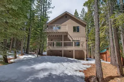 a house in the woods with snow on the ground at Sunrise Abode at Tahoe Donner - Luxurious New Build, Soaking Tub, HOA Amenities in Truckee